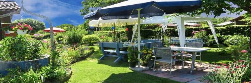 mesa con sombrilla y sillas de jardin